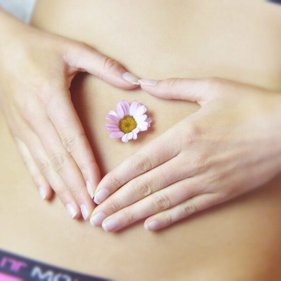 Girl laying with a small daisy on her tummy