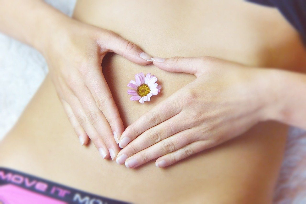 Girl laying with a small daisy on her tummy