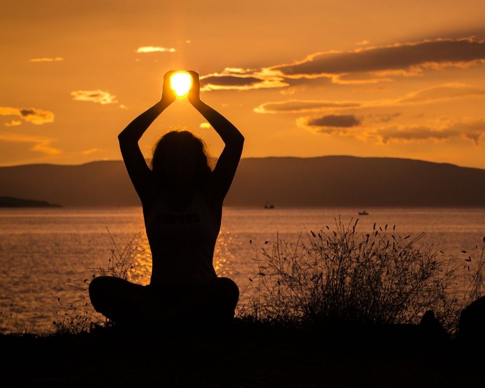 Silhouette of a woman doing yoga at sunset